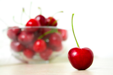 Cherries in glass dish. Cherry on wood and white background. - healthy eating and food concept