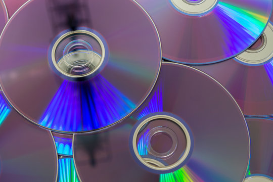 DVDs, digital optical disk storage. Group of DVDs and its characteristic light