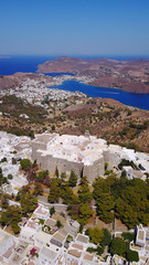 Aerial bird's eye view photo taken by drone of massive fortified stone Monastery of Saint John the Apostle with views to Aegean sea, Patmos island, Greece