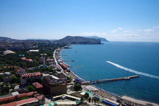 SUDAK, CRIMEA - June, 2018: View of the city beach from the walls of the Genoese fortress