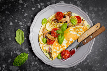Thin rolled omelet with fried vegetables, zucchini, tomato, onion, mushrooms, tasty healthy Breakfast,