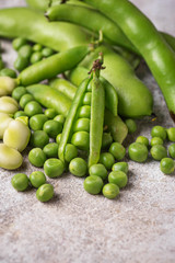 Fresh green peas and beans on light background