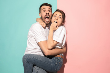 Portrait of the scared man and woman on pink and blue - obrazy, fototapety, plakaty