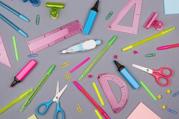 Fashion stylish workplace -  neon blue, pink, green, yellow office stationery collection on gray background, top view, pattern.