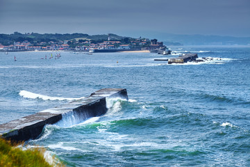 Saint Jean de Luz, France. Basque country. City views Ciboure and Castle and port of Socoa. Ocean waves breaking about the dam (Digue de Sainte-Barbe)