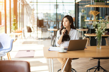Protrait of Beautiful businesswoman sitting at outdoor wood desk and working with laptop computer.