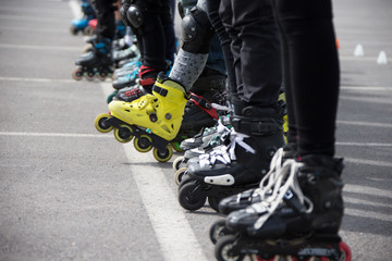 Close up view of wheels befor skating.Legs in rollskikovye skates are lined up in a row