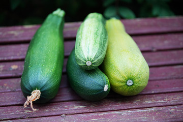 Young zucchini on a wooden background