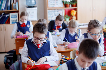 Obraz premium Schoolchildren play in building kit plastic blocks at a lesson in primary school
