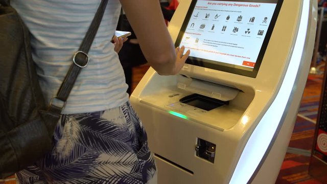 Woman prints a ticket at the airport terminal