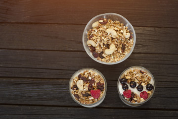 Granola with cashew in a cup with yoghurt. Dark wooden background