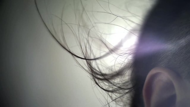 Hair silhouette on white background. Hair blowing in wind over ear. Young man head with modern hairstyle. Close up of long hair flying in wind long hair. Male fashion model in studio