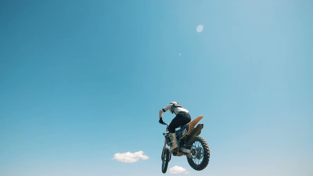 Underside view of a motorcyclist jumping with his motorbike