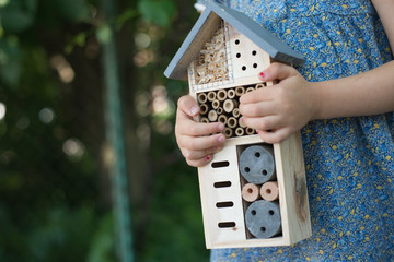 Green schooling. Girl holding insect hotel