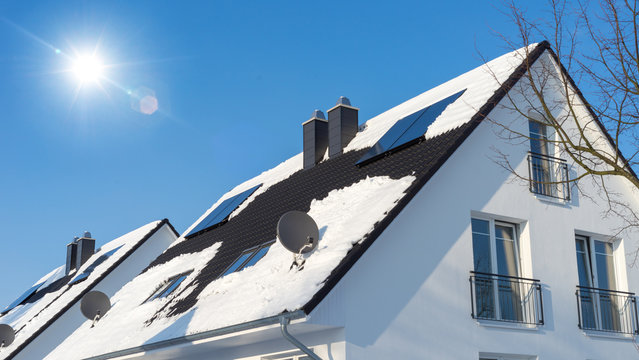 Haus mit Solarzellen auf dem Dach im Winter