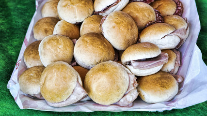 Tray with sandwiches stuffed with mortadella and salami - selective focus