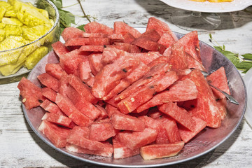 Serving dish with many slices of cold watermelon ready to eat - selective focus