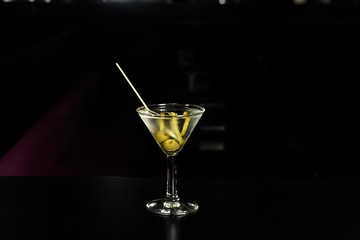 Classic glass of dry Martini with  olive and with a lemon twist, isolated.