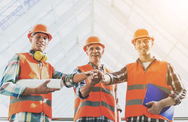 Standing Industrial Engineers in Vests and Helmets