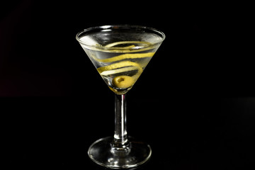 Classic glass of dry Martini with  olive and with a lemon twist,isolated.