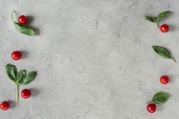 Naklejka na ściany i meble flat lay with arranged cherry tomatoes and spinach on grey tabletop