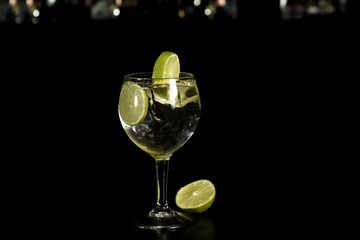 A glass of Gin Tonic cocktail drink with ice cubes  and a slice of lime ,Isolated .