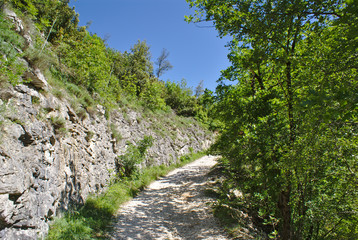 Strada con affianco parete di pietra