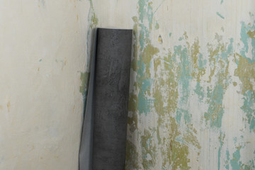 Roll of wallpaper against a concrete wall