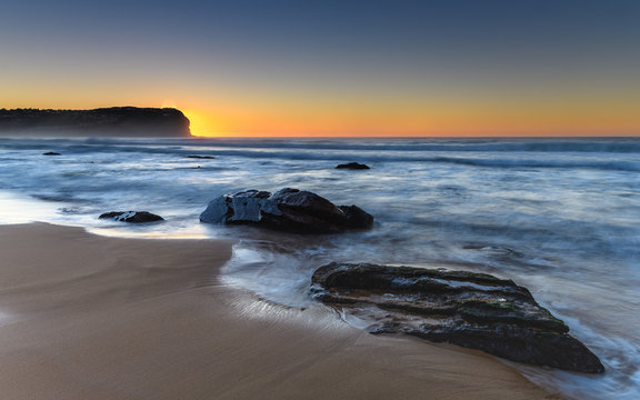 Sunrise Seascape with Rocks and Headland