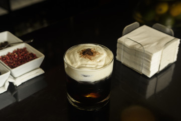 White Russian Cocktail with coffee beans and cinnamon garnished .