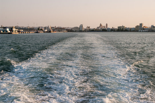  View of the city of Cadiz (Andalucia, Spain), especially its Cathedral, with a fantastic sunset light from the ferry that connects it with El Puerto de Santa Maria. Summer of 2016. - Powered by Adobe