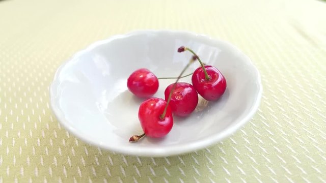 cherris falling into a white bowl