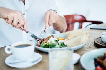 Man having delicious and healthy breakfast in restaurant. Close up of healthy nutritious dish