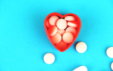 Heart-shaped pills. The concept of treating heart disease