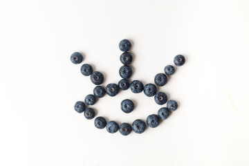 Eye with three eyelashes of blueberries on white background