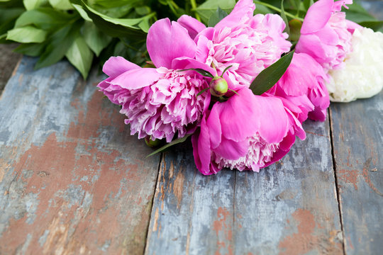 Peony background. Pink and peonies on wooden table with place for text. Spring flower peony. Happy Mothers Day. Mother's Day greetings card. Mothers Day gift. Copy space.