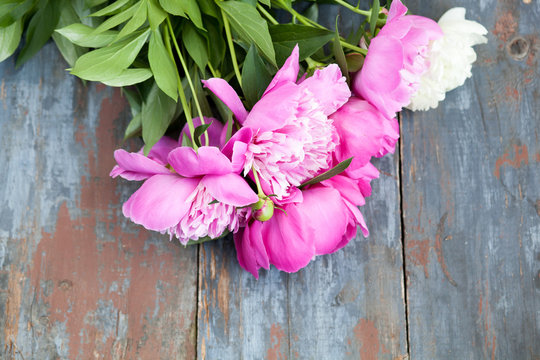 Peony background. Pink and peonies on wooden table with place for text. Spring flower peony. Happy Mothers Day. Mother's Day greetings card. Mothers Day gift. Copy space.