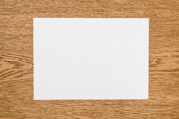 elevated view of empty white paper on wooden table