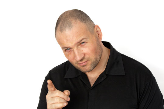 A muscular  man in a black suit  accuses someone and points a finger at him. Concept assuse