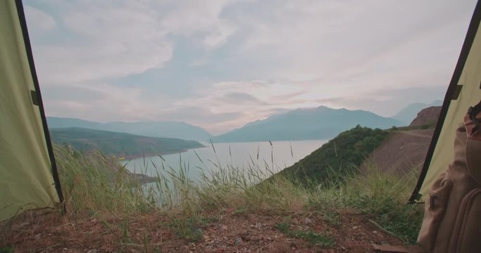 View of mountains and sky with clouds in sunset inside tent, 4k dollyshot