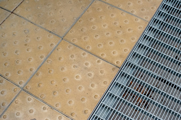 metal grill for draining water on the street and paving stones together
