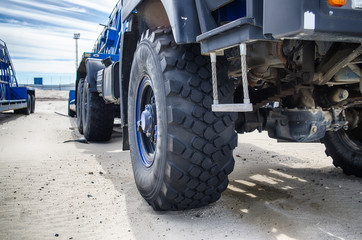 Truck in the sand, wheel close-up, construction. Traces from the truck on the sand.