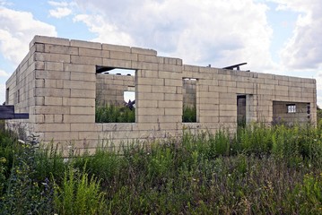 Fototapeta premium unfinished white brick house against the sky in the grass