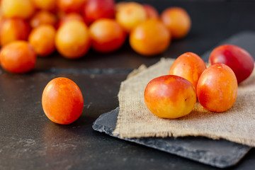 Fresh and ripe wild plum or cherry-plum on black surface.