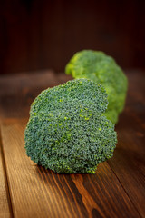 Big and ripe broccoli florets on wooden table.