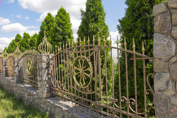 stone fence with forged metal bars