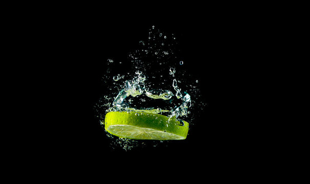 Lemonenscheibe / Limettenscheibe f&auml;llt ins Wasser (Wasserblasen)