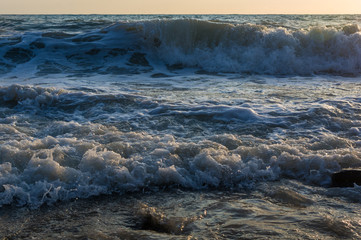 sea landscape is a pebbly beach with waves in white foam