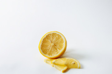  Half a juicy fresh lemon and two slices on a white background