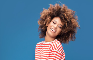 Smiling afro woman in sailor style shirt.